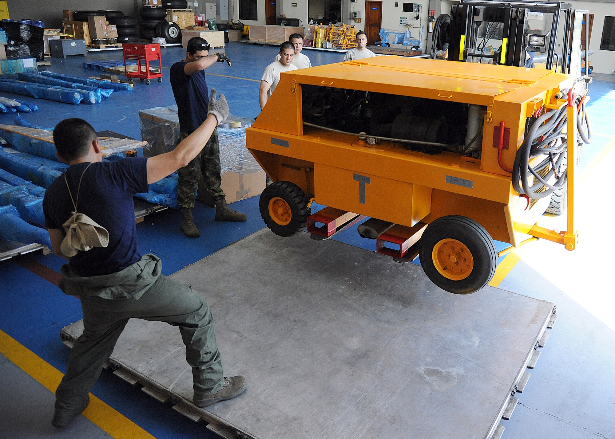 Members of the 571st Mobility Support Advisory Squadron and the Colombian air force, position a generator onto a pallet before loading it onto an aircraft during an Air Mobility Command Building Partner Capacity mission at General Alberto Pauwels Rodriguez Air Base in Barranquilla, Colombia, June 27.  (U.S. Air Force photo by Tech. Sgt. Lesley Waters)