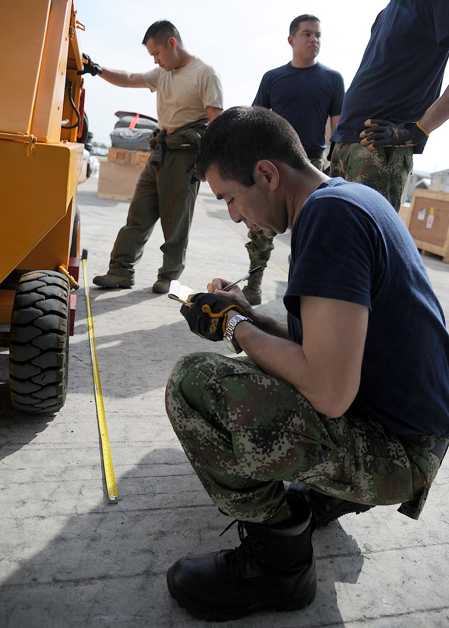 Members of the 571st Mobility Support Advisory Squadron and the Colombian air force, get dimensions for a generator for loading onto aircraft during an Air Mobility Command Building Partner Capacity mission at General Alberto Pauwels Rodriguez Air Base in Barranquilla, Colombia, June 27.  (U.S. Air Force photo by Tech. Sgt. Lesley Waters)