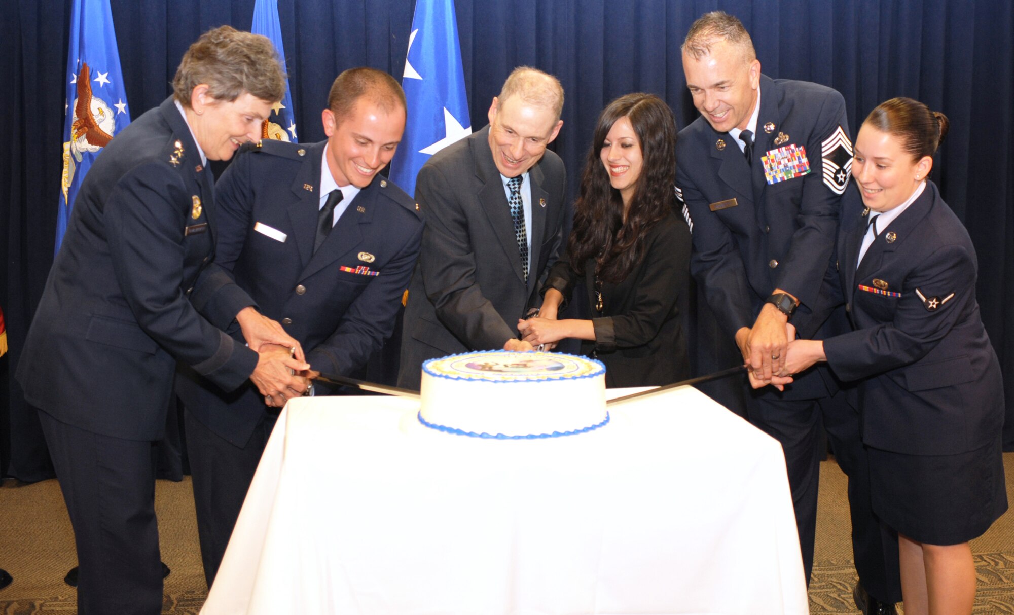 The Space and Missile Systems Center’s youngest officer, civilian and enlisted airman are joined by Lt. Gen. Ellen Pawlikowski, SMC commander;  Douglas Loverro, SMC executive director; and Chief Master Sgt. Jonathan Rossetti, 61st Medical Squadron superintendent;  in cutting the ceremonial cake marking SMC’s 58th birthday, June 27. (Photo by Sarah Corrice)