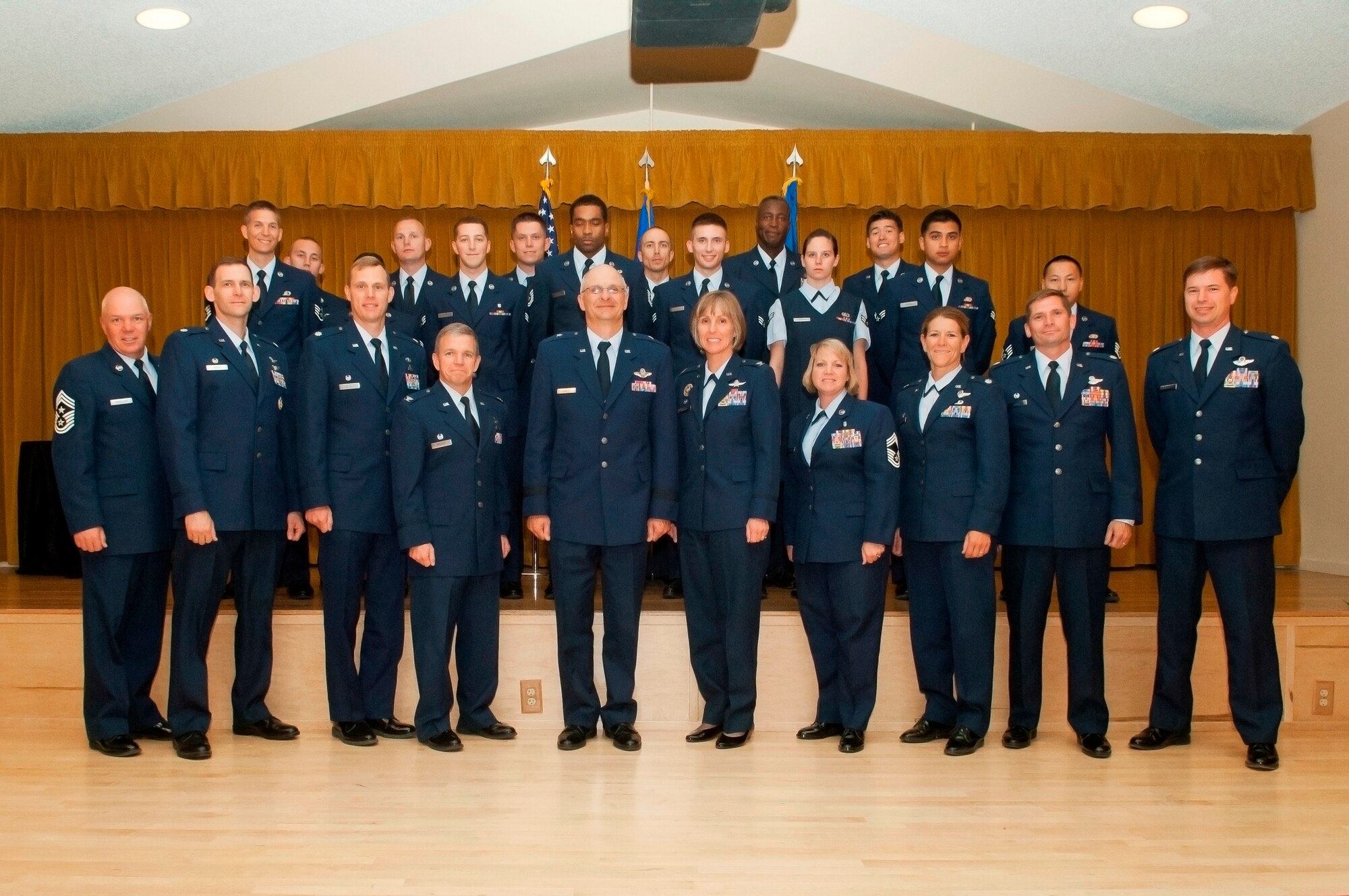 Edwards Air Force Base leadership pose in front of June's promotee class June 29 at Club Muroc. (U.S. Air Force photo by Ethan Wagner)