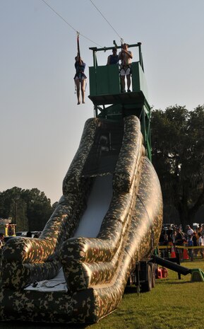 Master Sgt. Jason Miller, 373rd Training Squadron Command Support Staff non-commissioned officer in charge and his daughter, Ana, descend a zip-line June 29, during the 2012 Freedom Fest at Marrington Plantation at Joint Base Charleston – Weapons Station. Nearly 1,500 Sailors, Airmen, civilians and their families attended the fest which included food, drinks, festival rides, music and fireworks. (U.S. Air Force photo/Airman 1st Class Jared Trimarchi)