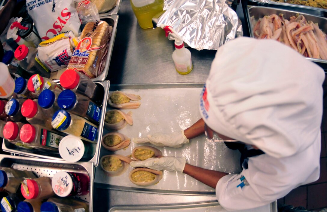 Andresa Osgard, a civilian cook with 919th Force Support Squadron, fills fish with bread stuffing for the lunch meal at the dining facility on Duke Field, Fla. The civilian staff plays a key role in the monthly support of the dining facility and helped the unit win its seventh Hennessy Trophy since 2000. The Hennessy Trophy is an annual award presented to Air Force installations with the best food-service programs. (U.S. Air Force photo by: Tech. Sgt. Cheryl L. Foster)