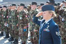 Air Force Reserve Staff Sgt. Kalee Lint, 910th Airlift Wing Non-Commissioned Officer in Charge of Development and Training Flight, leads a group of Junior Reserve Officer Training Corps cadets  and 910th Airlift Wing members in saluting the U.S. flag during the playing of the National Anthem, here, June 22. Loudspeakers around YARS play Retreat and the National Anthem at the end of each duty day. The cadets were here for a several day encampment designed to provide a military experience with drill, customs and courtesies, team building and other focused activities.
