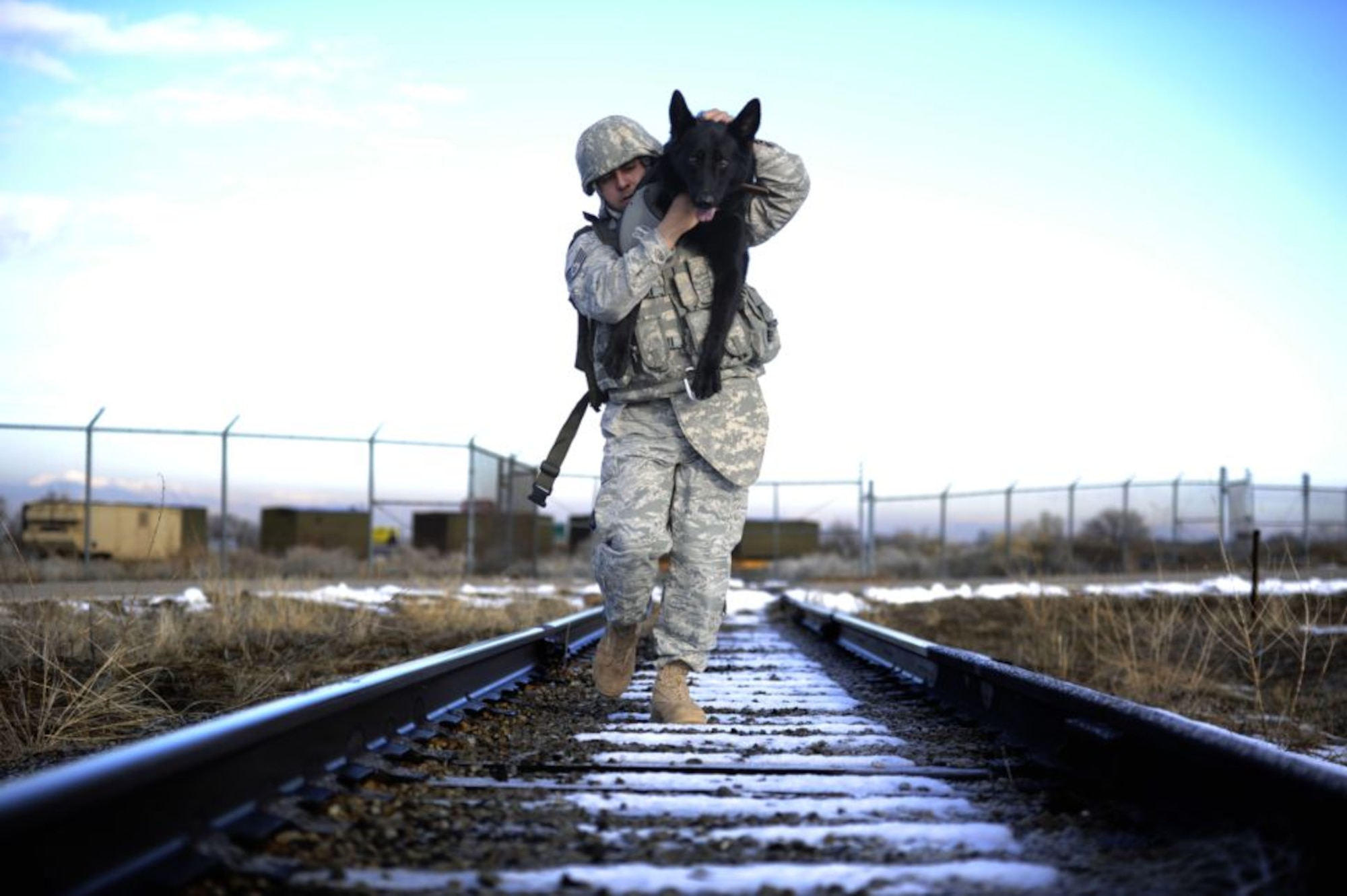 Staff Sgt. Erick Martinez, a military dog handler at Hill Air Force Base, Utah, uses an over-the-shoulder carry with his dog, Argo II. This exercise helps build trust, loyalty, and teamwork for Sergeant Martinez and Argo II, who have only been working together for two months (U.S. Air Force photo by Airman 1st Class Allen Stokes)