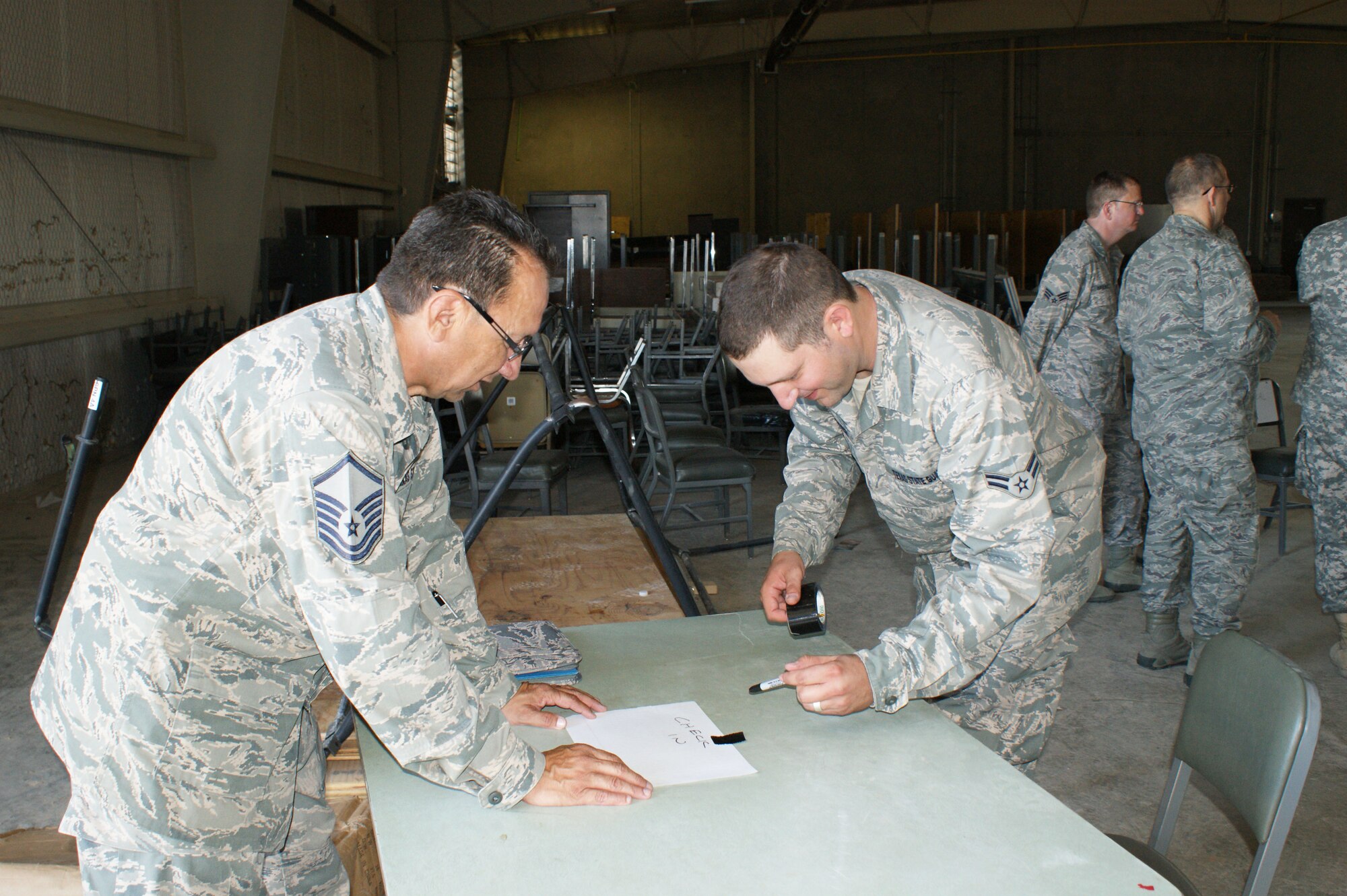 Master Sgt. Jesse Doria (left) and Airman 1st Class Jeremy Parker, both with the 482nd Air Support Group at Sheppard Air Force Base, Texas, practice setting up a shelter entry control point during training Jun. 29, 2012.  The 482nd ASG is at Camp Bowie Training Center in Brownwood, Texas, for the Texas State Guard's 2012 annual training.    (Texas State Guard photo/SMSgt Dan Hawkins)