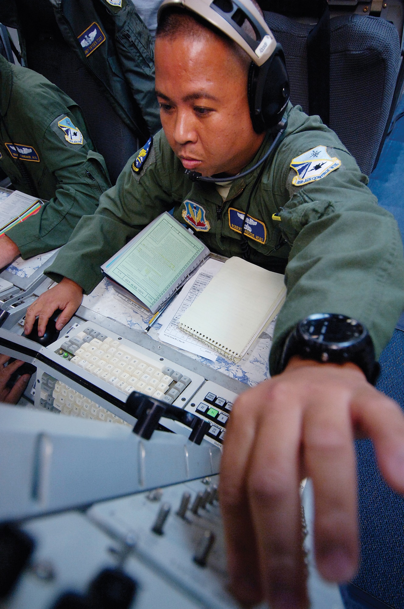 Airborne Surveillance Technician Master Sgt. Roberto Abcede closely monitors a large radar screen making adjustments as needed to keep his eye on aerial activity during a recent E-3 Sentry training flight for members of the 965th Airborne Air Control Squadron. Varied colors of blinking dots, dashes and circles are interpreted by the AWACS members who keep their skills sharp with training in preparation for real-world missions anywhere in the world.  (Air Force photo by Margo Wright)