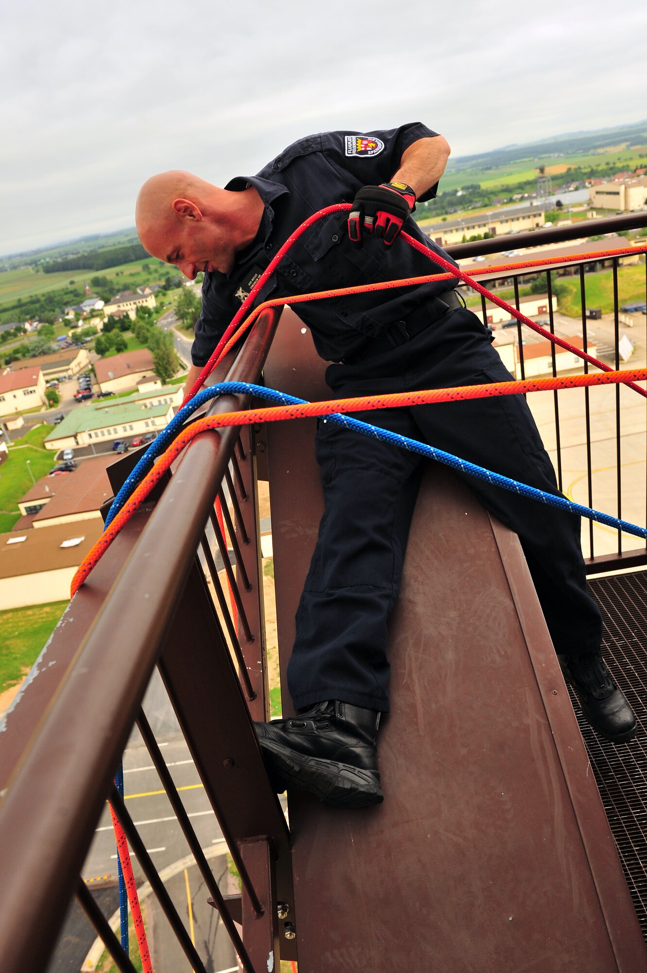SPANGDAHLEM AIR BASE, Germany – Gerd Mueller, 52nd Civil Engineer Squadron firefighter, pulls up a rope with rappelling equipment attached during training at the control tower here June 29. Firefighters from the 52nd CES complete rappelling training so they can be rescue certified to perform rope and high-angle rescue techniques. The firefighters train annually to ensure the force maintains the highest level of proficiency and readiness for rapid rescue attempts in demanding situations. (U.S. Air Force photo by Airman 1st Class Dillon Davis/Released)