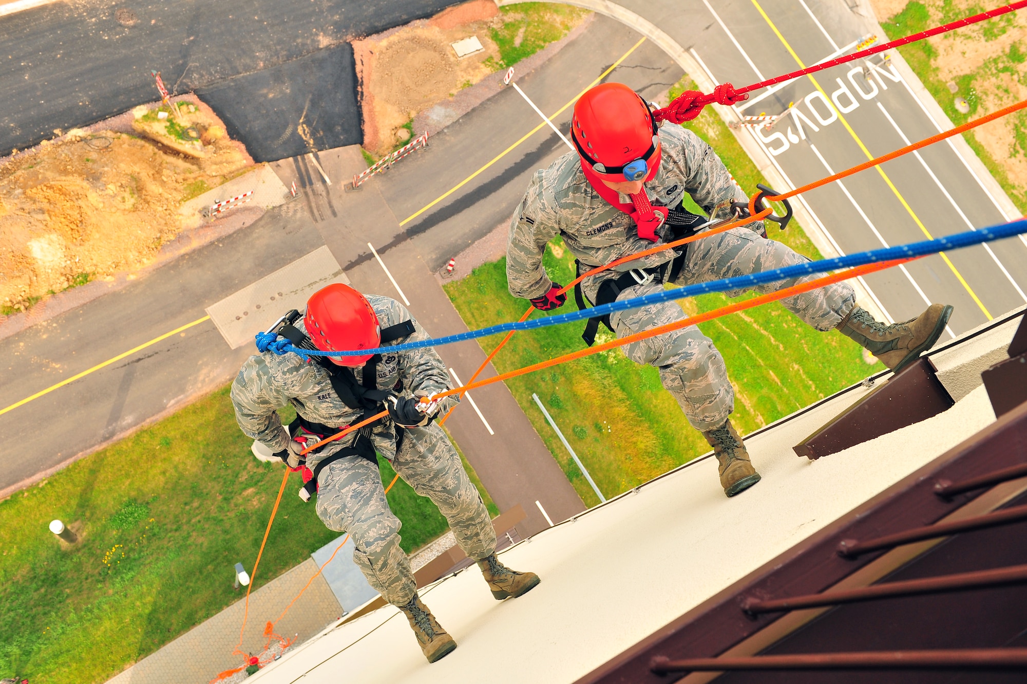 SPANGDAHLEM AIR BASE, Germany – Lt. Col. William Kale, left, 52nd Civil Engineer Squadron commander, and Airman 1st Class Tyler Clemons, 52nd CES firefighter, rappel down the control tower during training here June 29. Firefighters from the 52nd CES complete rappelling training so they can be rescue certified to perform rope and high-angle rescue techniques. The firefighters train annually to ensure the force maintains the highest level of proficiency and readiness for rapid rescue attempts in demanding situations. (U.S. Air Force photo by Airman 1st Class Dillon Davis/Released)