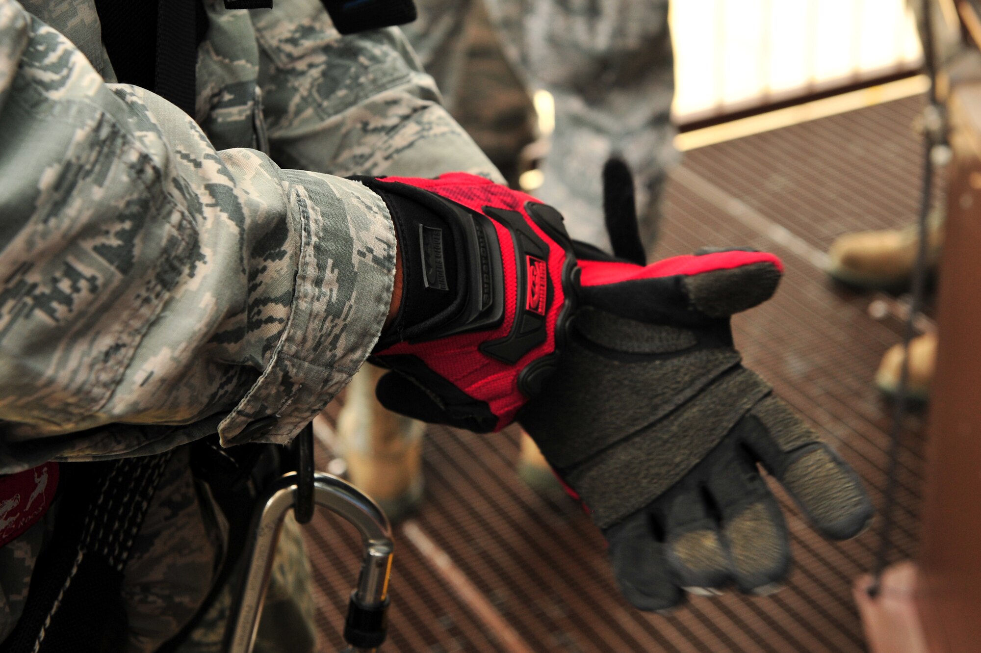 SPANGDAHLEM AIR BASE, Germany – Airman 1st Class Cory Gonzales, 52nd Civil Engineer Squadron firefighter, puts on gloves before rappel training at the control tower here June 29. Firefighters from the 52nd CES complete rappelling training so they can be rescue certified to perform rope and high-angle rescue techniques. The firefighters train annually to ensure the force maintains the highest level of proficiency and readiness for rapid rescue attempts in demanding situations. (U.S. Air Force photo by Airman 1st Class Dillon Davis/Released)