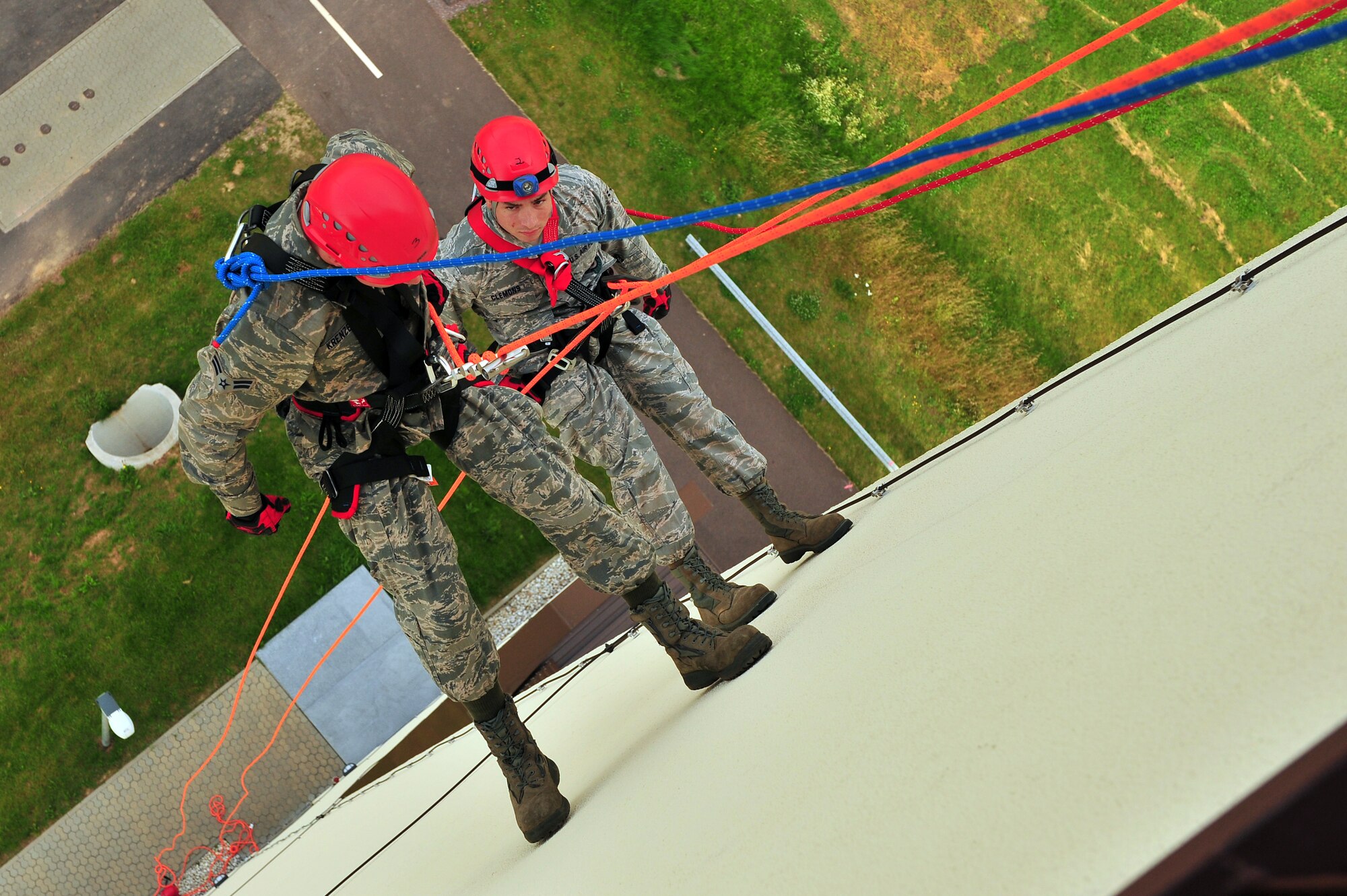 SPANGDAHLEM AIR BASE, Germany – Airmen 1st Class Jonathan Krenzer, left, and Tyler Clemons, 52nd Civil Engineer Squadron firefighters, rappel down the control tower during training here June 29. Firefighters from the 52nd CES complete rappelling training so they can be rescue certified to perform rope and high-angle rescue techniques. The firefighters train annually to ensure the force maintains the highest level of proficiency and readiness for rapid rescue attempts in demanding situations. (U.S. Air Force photo by Airman 1st Class Dillon Davis/Released)