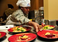 MINOT AIR FORCE BASE, N.D. -- Senior Airman Antona Gaskins, 741st Missile Squadron missile chef, presents her teams award winning dishes to the judges during the “Warrior Chef 2012” competition, here June 27. The annual competition gave Team Minot chefs the chance to demonstrate their skills and be recognized for their talents in a friendly environment. It was a true test of culinary mastery as a team from each wing went head-to-head in a 45-minute, ultimate dish showdown. (U.S. Air Force photo/Senior Airman Desiree W. Esposito)
