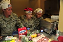 MINOT AIR FORCE BASE, N.D. -- Senior Airmen; Amanda Greenlee, Jennifer Frost Fa Pham, all from the 5th Force Support Squadron, take a look at the proteins provided for the “Warrior Chef 2012” competition, here June 27. The annual competition gave Team Minot chefs the chance to demonstrate their skills and be recognized for their talents in a friendly environment. It was a true test of culinary mastery as a team from each wing went head-to-head in a 45-minute, ultimate dish showdown. (U.S. Air Force photo/Senior Airman Desiree W. Esposito)