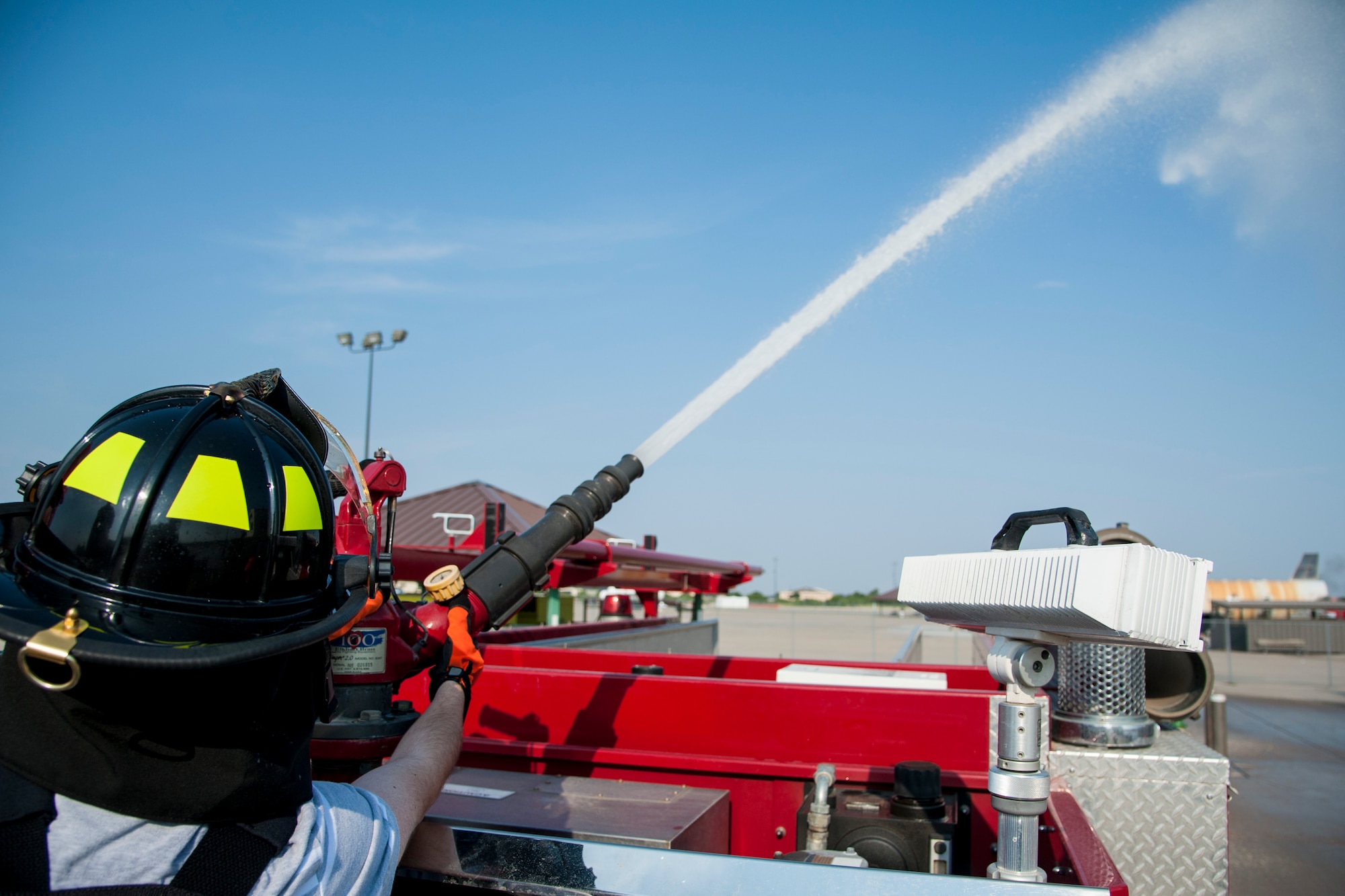 GOODFELLOW AIR FORCE BASE, Texas-- Maxwell “Trey” Pons III, Honorary Air Force firefighter, sprays a turret on top of a fire truck at the Louis F. Garland DOD Fire Academy June 28. Pons, who is autistic, sight impaired and hearing-impaired, accomplished his dream to become a firefighter by going through each training block in a day at the Fire Academy. (U.S. Air Force photo/Airman 1st Class Michael Smith)