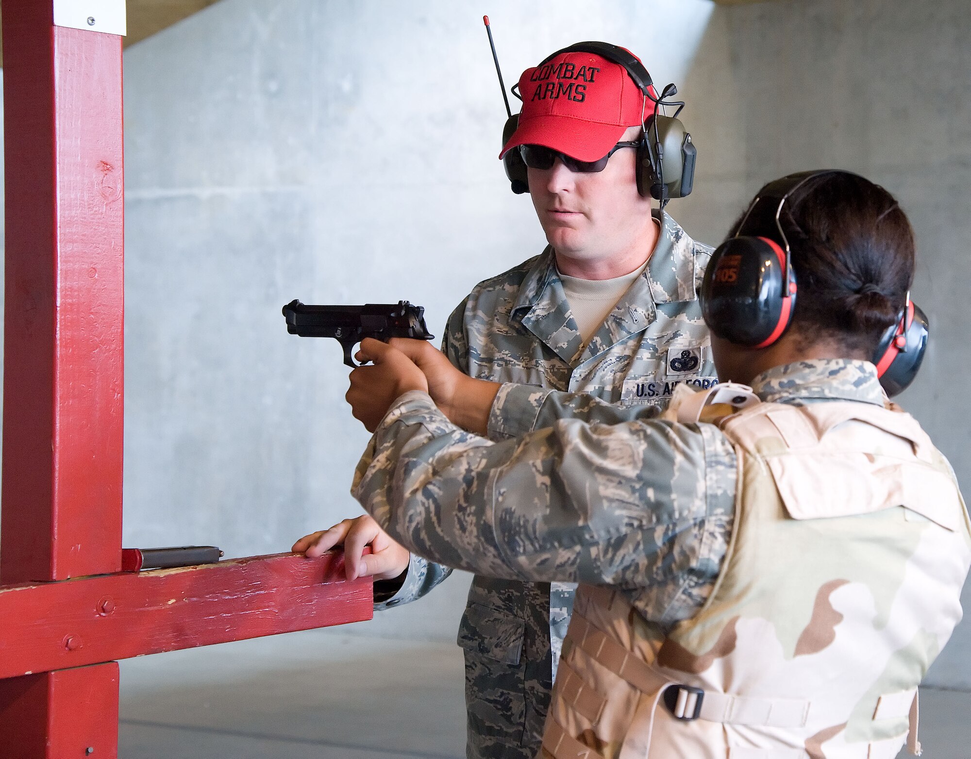 Master Sgt. Daniel Hoyme, superintendent of logistics and resources with the 436th Security Forces Squadron, assists 2nd Lt. Emma Barrett with her shooting stance June 28, 2012, during a Combat Arms Training and Maintenance class at Dover Air Force Base, Del. Team Dover members must qualify on a weapons in order to deploy. (U.S. Air Force photo by Adrian R. Rowan)