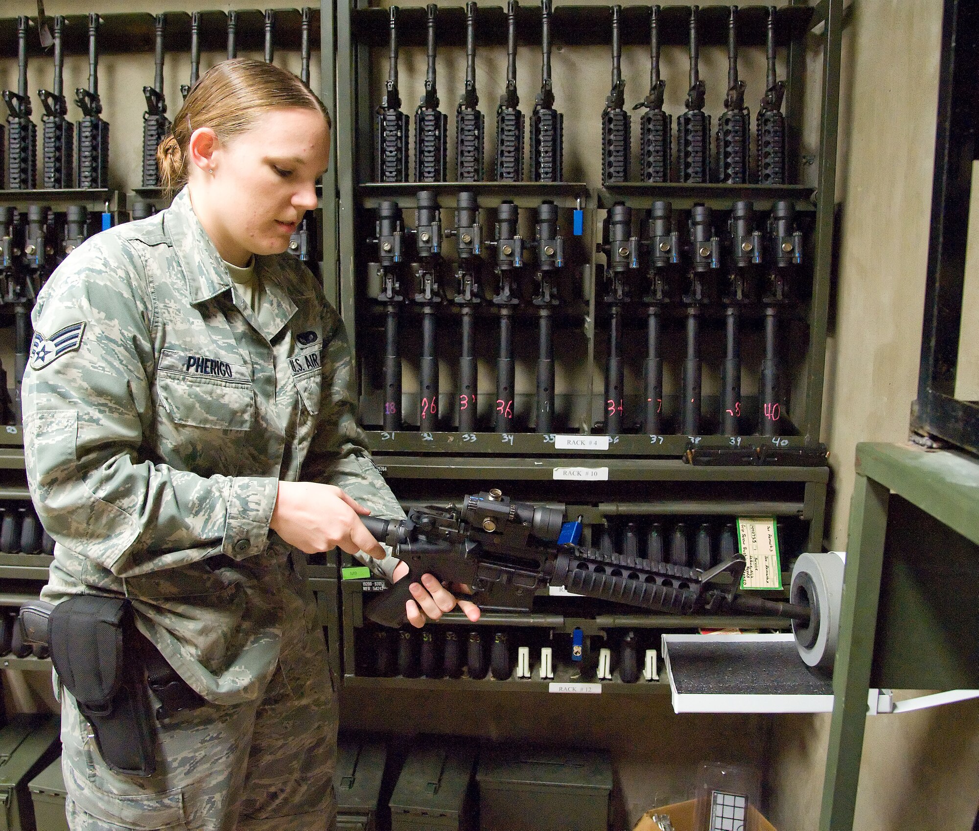 Senior Airman Ginnefer Pherigo, a Combat Arms Training and Maintenance instructor with the 436th Security Forces Squadron, clears a weapon for a student June 28, 2012, at Dover Air Force Base, Del. Clearing a weapon is an important part of safe weapons handling. (U.S. Air Force photo by Adrian R. Rowan)