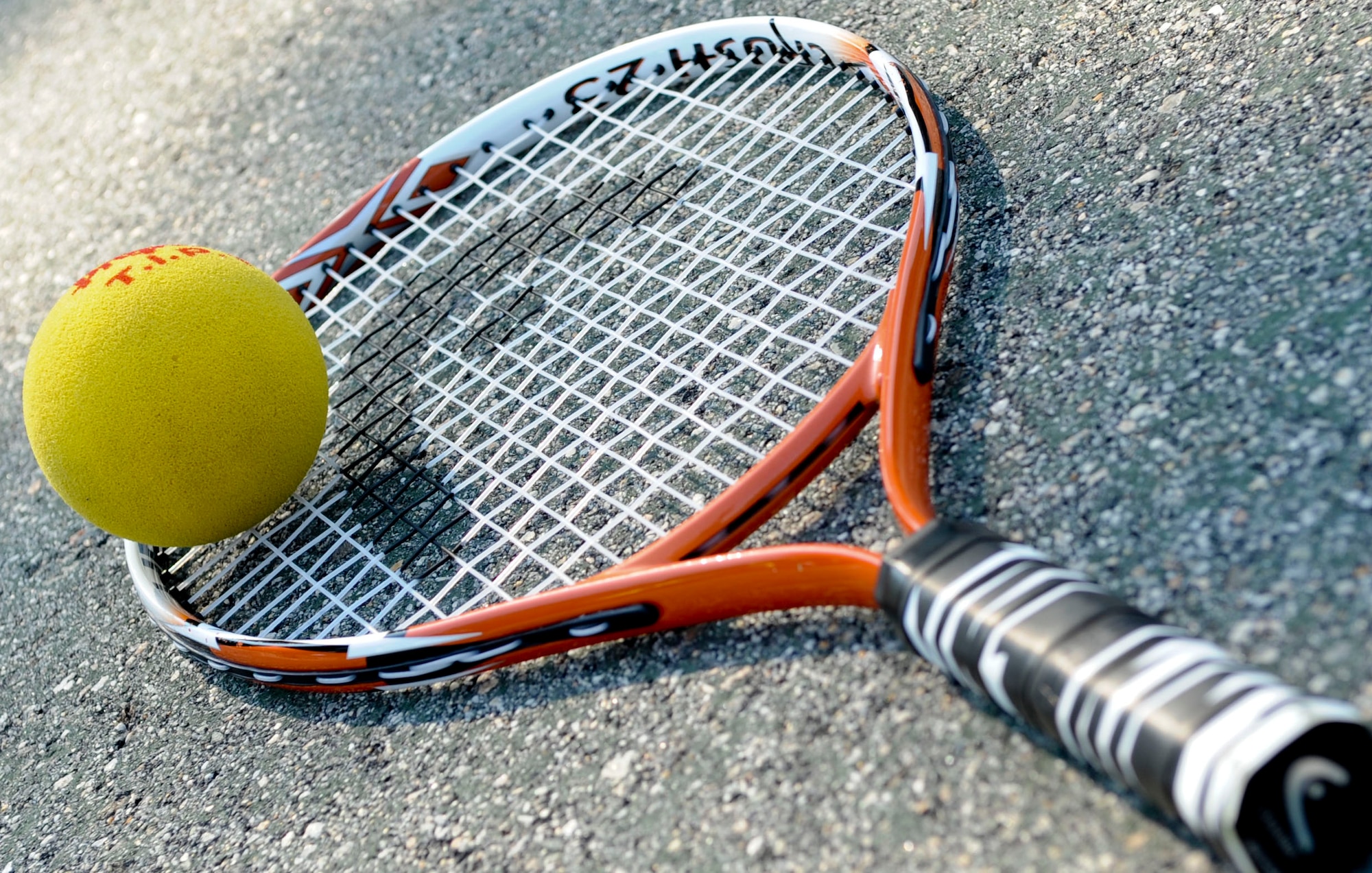 A tennis racket lies on the court, waiting for children to play with it, as part of the new tennis program being offered by the Child Youth and School Services office, June 28, 2012 at Fort Eustis, Va. The new program will be offered twice a year to children ages 10 and under. (U.S. Air Force photo by Senior Airman Wesley Farnsworth/Released)