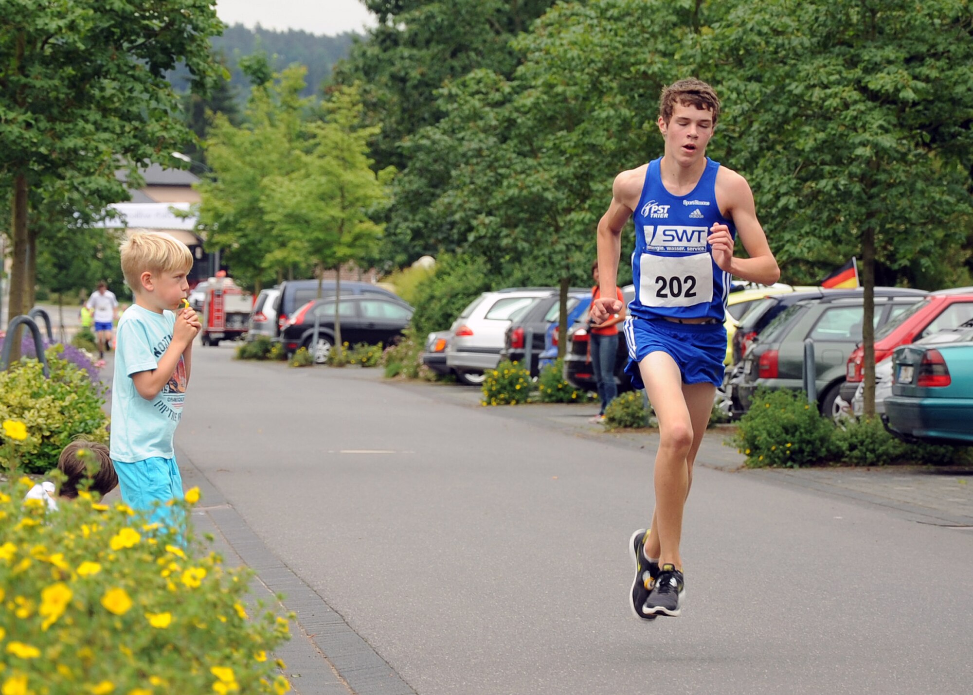 SPANGDAHLEM AIR BASE, Germany – A child blows a whistle as Hagan Betzler, German-American Friendship Run participant, approaches the finish line of the five kilometer race during the ninth annual run in Binsfeld July 1. Betzler finished the race in first place in 17 minutes. More than 300 Germans and Americans participated in the run, which focuses on building partnerships and relationships between the two countries’ peoples. (U.S. Air Force photo by Staff Sgt. Daryl Knee/Released)
