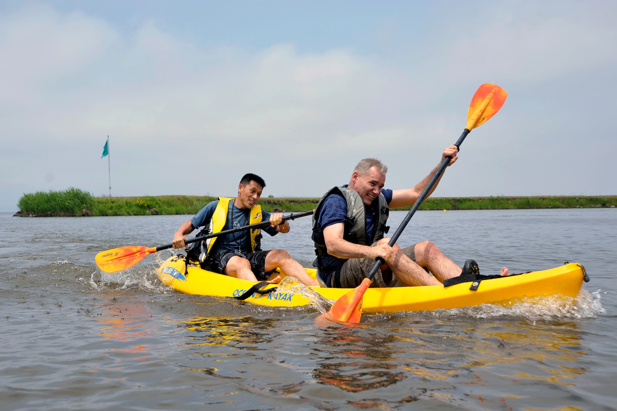 U.S. Air Force Chief Master Sgt. James Laurent, right, 35th Fighter Wing command chief, and Japan Air Self Defense Force Warrant Officer Takahiro Imagawa, left, 3rd Air Wing senior enlisted advisor, paddle to the finish line during Sports Day at Misawa Air Base, Japan, June 30, 2012. Nine teams compiled of distinguished members of the Misawa City community, United States Air Force and Japan Air Self Defense Force competed in the day’s events. (U.S. Air Force photo by Staff Sgt. Nathan Lipscomb/Released)