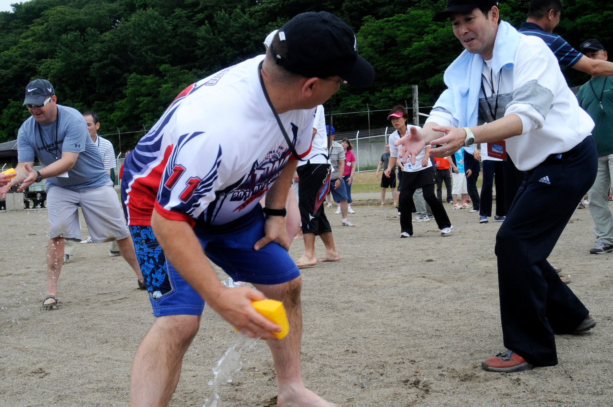 U.S. Air Force Col. John Griffin, 35th Mission Support Group commander, passes a sponge to his teammate during the fill the container event at Misawa Air Base, Japan, June 30, 2012. The event was part of Sports Day, which was held to increase bilateral relations and create new friendships. (U.S. Air Force photo by Airman 1st Class Zachary Kee)