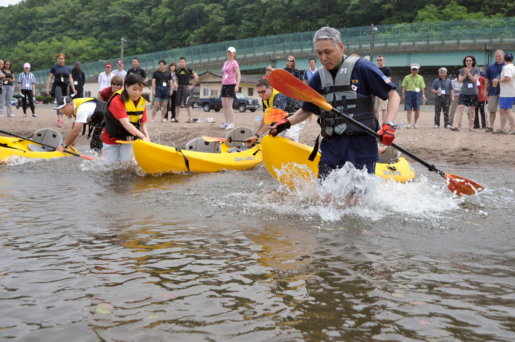 Participants in the Sports Day event compete in the kayak relay race at Misawa Air Base, Japan, June 30, 2012. Despite differences in culture, the Japanese and U.S. participants discovered they had a great deal in common as they competed together in various events.  (U.S. Air Force photo by Staff Sgt. Nathan Lipscomb/Released)