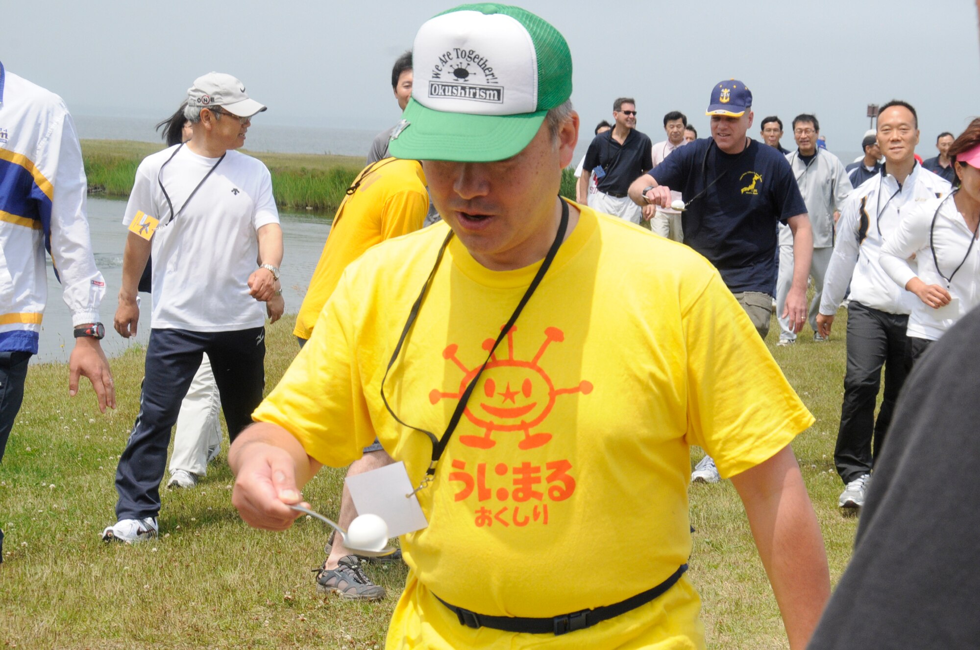 Shoji Kurotaki, a member of team Mustang, leads the pack during the egg carry event at Sports Day at Misawa Air Base, Japan, June 30, 2012. The event was held at the base beach to give servicemembers and members of the local community a chance to create new friendships. (U.S. Air Force photo by Airman 1st Class Zachary Kee/Released)