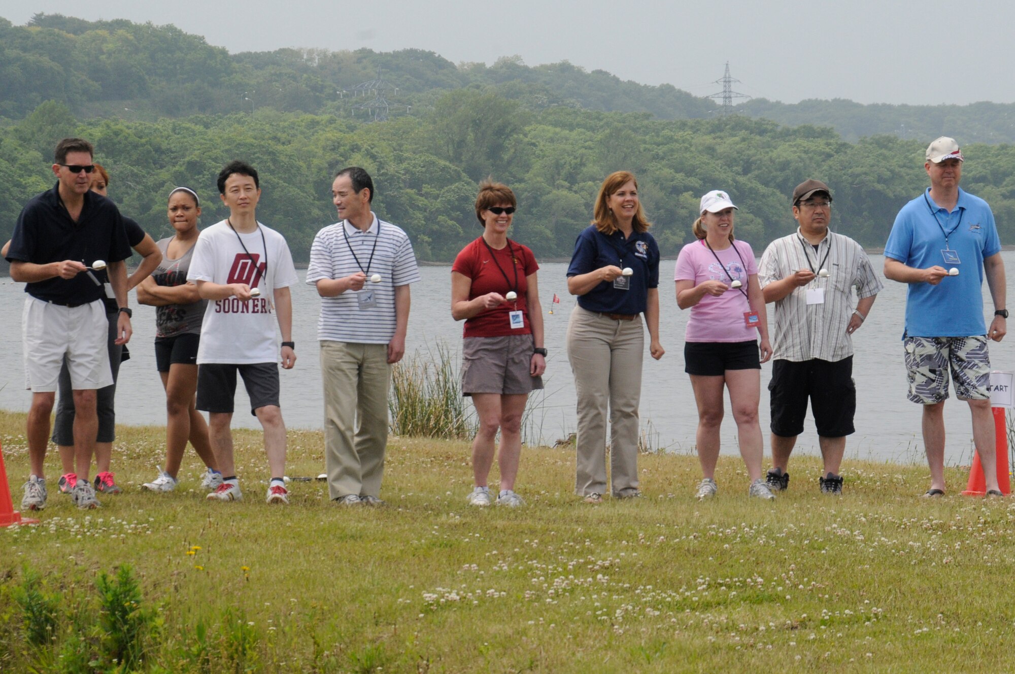 Members from Misawa Air Base and the local community line up to start the egg carry event at the base beach at Misawa Air Base, Japan, June 30, 2012. The event was a part of Sports Day, intended to strengthen bilateral relations and provide friendly competition for the Americans and Japanese. (U.S. Air Force photo by Airman 1st Class Zachary Kee/ Released)