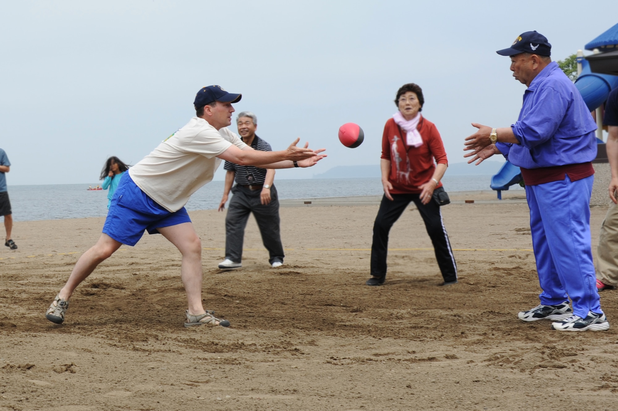U.S. Air Force Col. Michael Rothstein, left, 35th Fighter Wing commander, tosses a ball to Kazumasa Taneichi, right, Misawa City mayor, during a competition at the 2012 Sports Day at Misawa Air Base, Japan, June 30, 2012. During this competition called Nerf Newcomb, teams scored points by making the opposing team miss the ball. The sports day promoted Japanese-American relations by having bilateral teams compete in various events. (U.S. Air Force photo by Airman 1st Class Kia Atkins/Released)