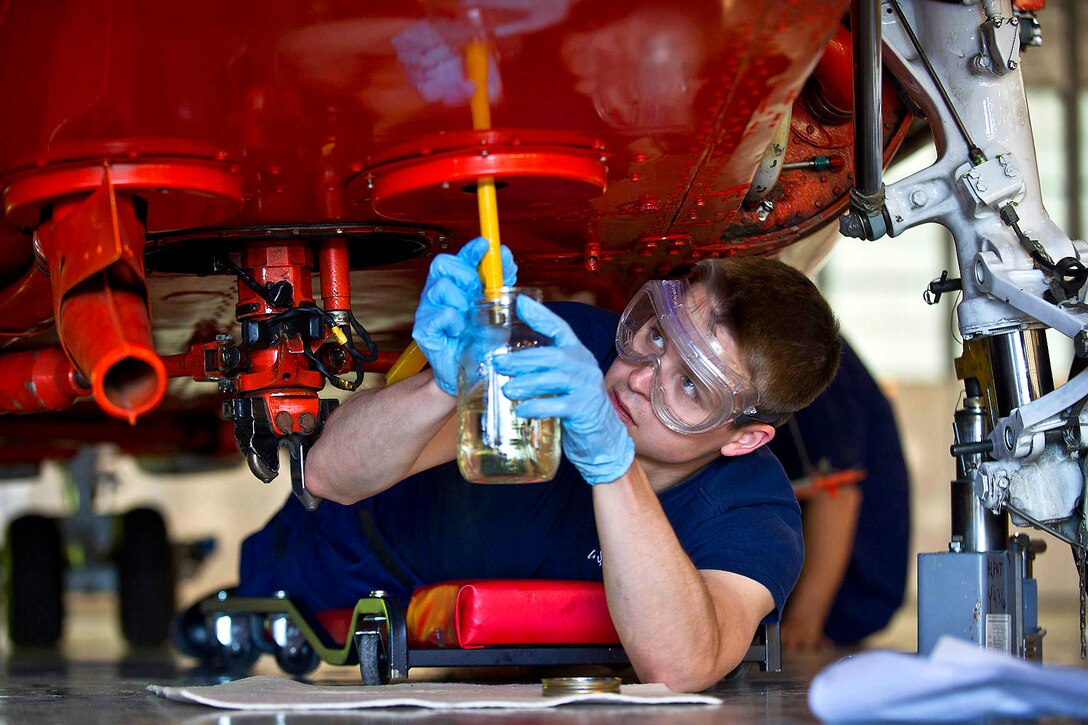 Coast Guard Airman Lucas Dellams takes a fuel sample from an HH-65B Dolphin helicopter during a routine seven-day maintenance inspection on Coast Guard Air Station Kodiak, Alaska, June 26, 2012. Dellams is an aviation maintenance technician.