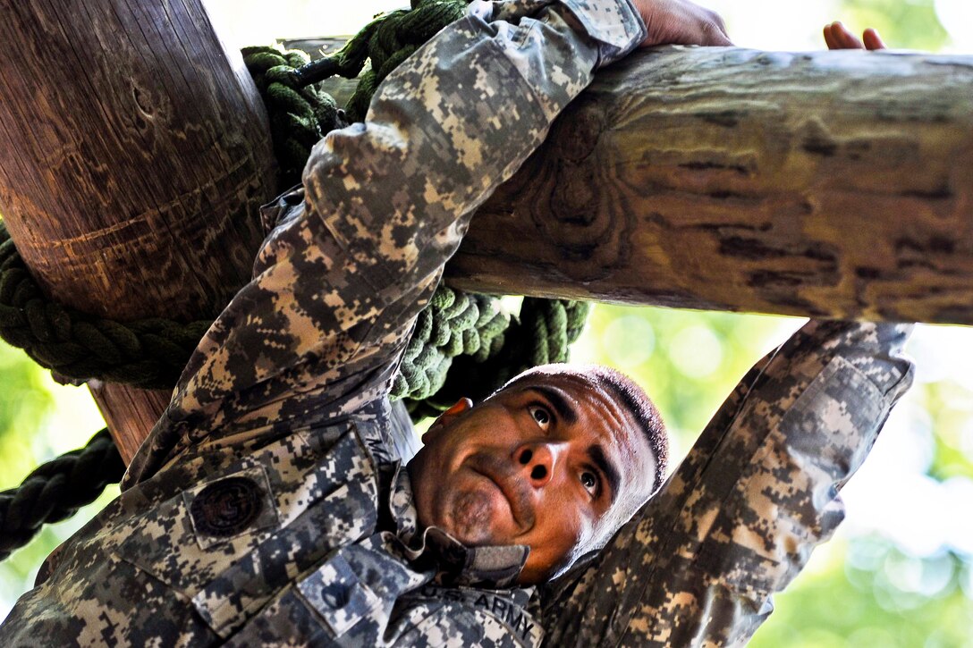 Army Staff Sgt. Victor Marquez-Rodriguez Sr. crosses a log during a confidence course during the annual Drill Sergeant of the Year competition on Fort Eustis, Va., June 27, 2012.