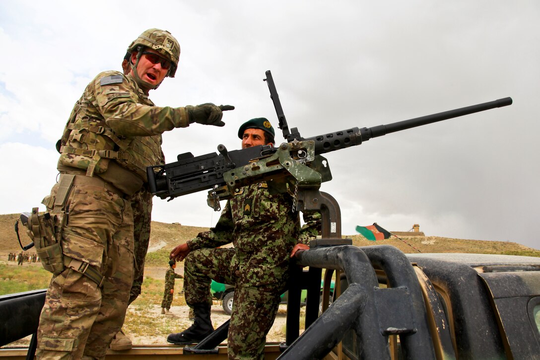 U.S. Army Sgt. James Misch shows Afghan soldiers how to load an M2 .50-caliber machine gun during basic marksmanship training in Paktika province, Afghanistan, June 18, 2012.
