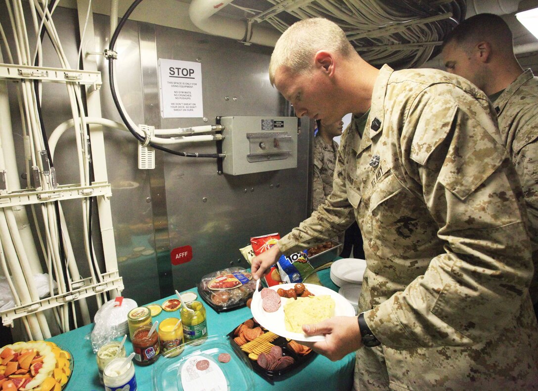 Petty Officer 1st Class Logan Viers, a hospital corpsman from the shock and trauma platoon with Combat Logistics Battalion 24, 24th Marine Expeditionary Unit, fills his plate with food during a celebration of the 114th birthday of the U.S. Navy Hospital Corps aboard the USS New York, June 17, 2012. The 24th MEU, along with the Iwo Jima Amphibious Ready Group, is currently deployed to the U.S Central Command area of operations as a theater reserve and crisis response force. The group is providing support for maritime security operations and theater security cooperation efforts in the U.S. Navy's 5th Fleet area of responsibility.