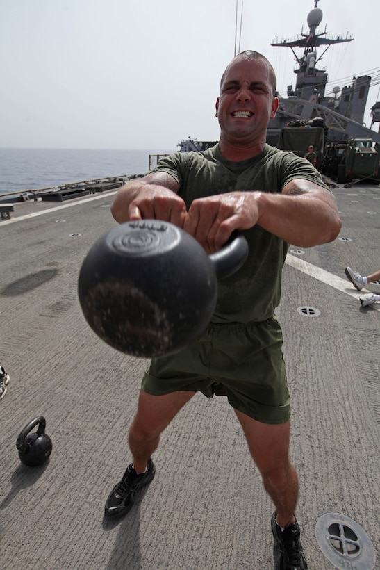 Staff Sgt. Jeffrey Perry, a Middlesex, N.J., native and the motor transportation chief with Motor Transportation Platoon, Combat Logistics Battalion 24, 24th Marine Expeditionary Unit, does kettle-bell swings during a CrossFit workout on the flight deck of the USS Gunston Hall, June 14, 2012. The 24th MEU, along with the Iwo Jima Amphibious Ready Group, is currently deployed to the U.S Central Command area of operations as a theater reserve and crisis response force. The group is providing support for maritime security operations and theater security cooperation efforts in the U.S. Navy's 5th Fleet area of responsibility.