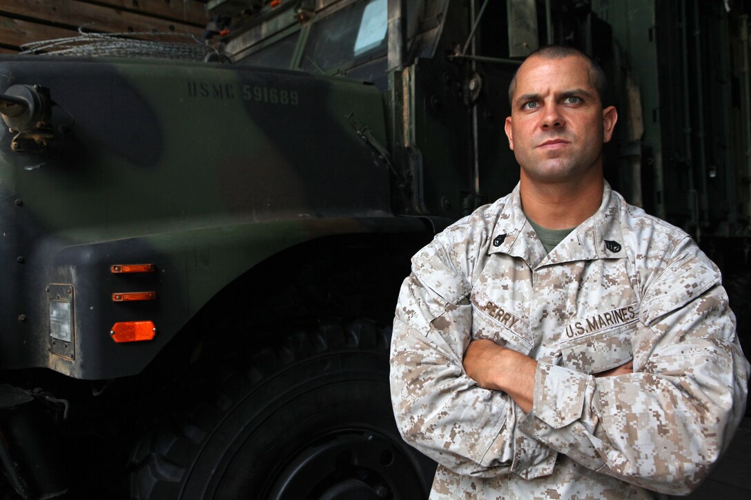 Staff Sgt. Jeffrey Perry, a Middlesex, N.J., native and the motor transportation chief with Motor Transportation Platoon, Combat Logistics Battalion 24, 24th Marine Expeditionary Unit, poses for a picture in front of a 7 ton truck in the USS Gunston Hall's well deck, June 17, 2012. The 24th MEU, along with the Iwo Jima Amphibious Ready Group, is currently deployed to the U.S Central Command area of operations as a theater reserve and crisis response force. The group is providing support for maritime security operations and theater security cooperation efforts in the U.S. Navy's 5th Fleet area of responsibility.