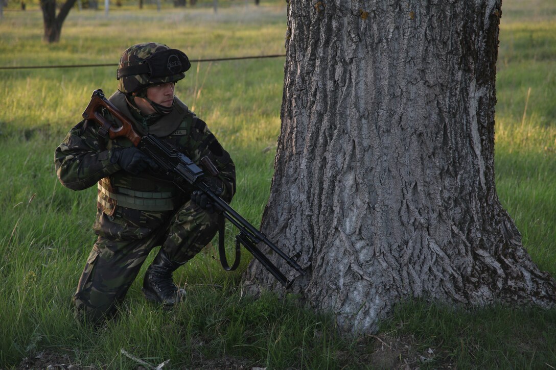A Romanian soldier scans the area during a foot patrol exercise in Timisoara, Romania. The patrol was part of a week-long training led by Marines of Black Sea Rotational Force 12 in an effort to enhance interoperability between the forces. During the training Marines and Romanian soldiers exchanged tactical knowledge and experiences. The Black Sea Rotational Force 12 is a Special-Purpose MAGTF with crisis response capabilities deployed to the region to enhance interoperability and promote regional stability.