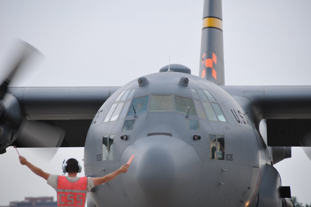 An Airman assigned to the 153rd Airlift Wing marshals a MAFFS-equipped C-130 on the flightline at the Wyoming Air National Guard base in Cheyenne, Wyo., July 3, 2012. MAFFS aircraft continue to operate in the Rocky Mountain region to assist with firefighting efforts. (U.S. Air Force photo by Airman 1st Class Nichole Grady)