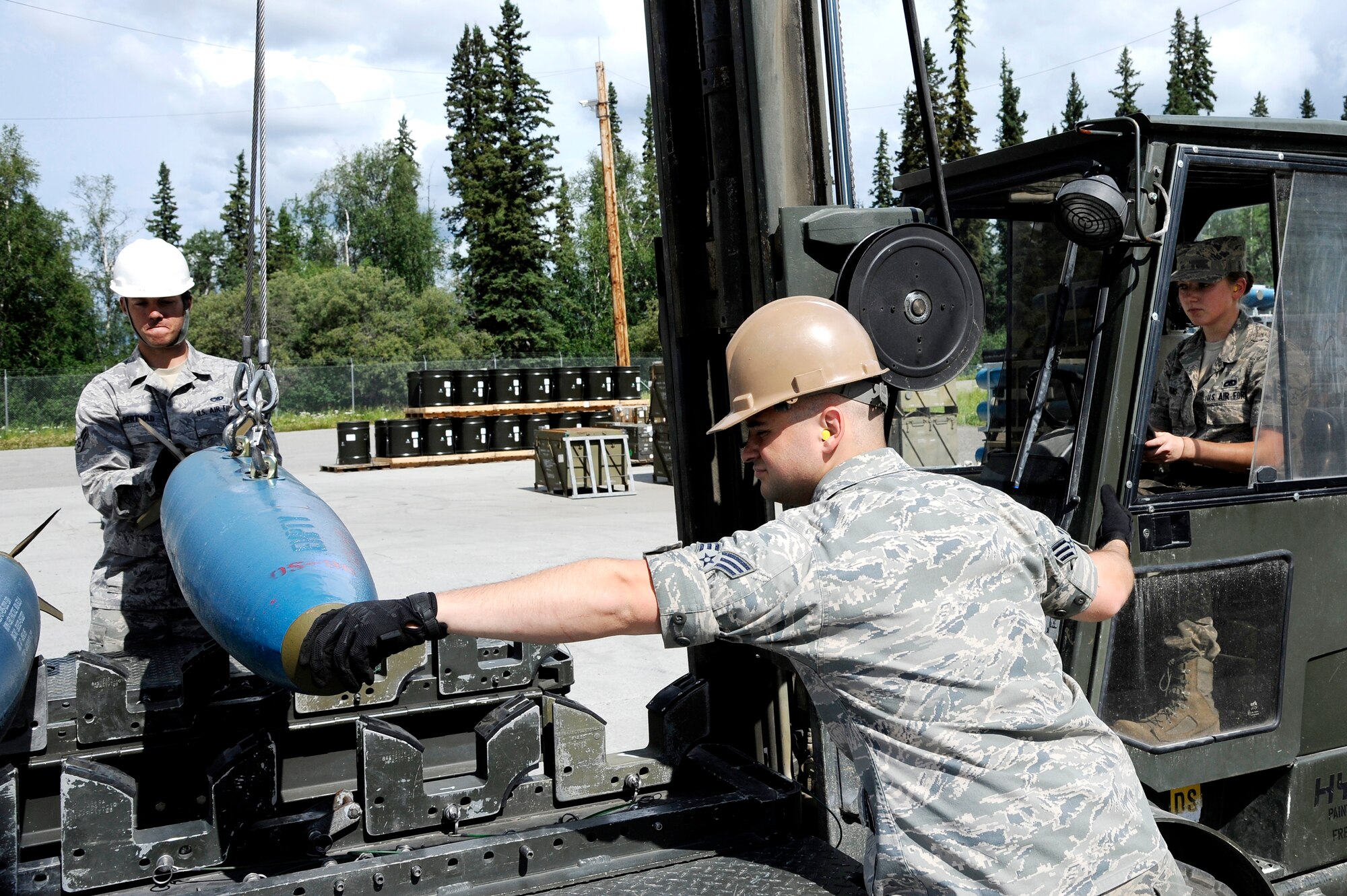 U.S. Air Force munitions crew chiefs from the 51st Munitions Squadron guide a bomb dummy unit on to a munitions handling unit July 2, 2012, Eielson Air Force Base, Alaska. (U.S. Air Force photo/Staff Sgt. Jim Araos)