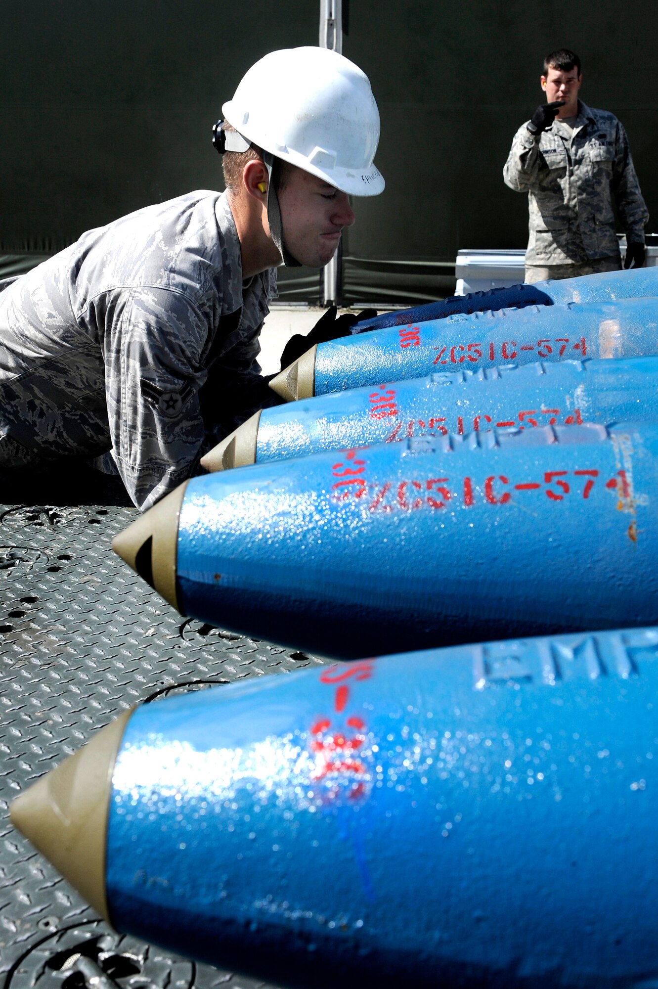 U.S. Air Force Senior Airman Thomas Johnson and Airman 1st Class John Berthold, 51st Munitions Squadron munitions crew chiefs, arrange bomb dummy units July 2, 2012, Eielson Air Force Base, Alaska. The BDU is regularly used by aircraft to simulate the ballistics of real air-to-ground weapons and does not carry explosives. (U.S. Air Force photo/Staff Sgt. Jim Araos)