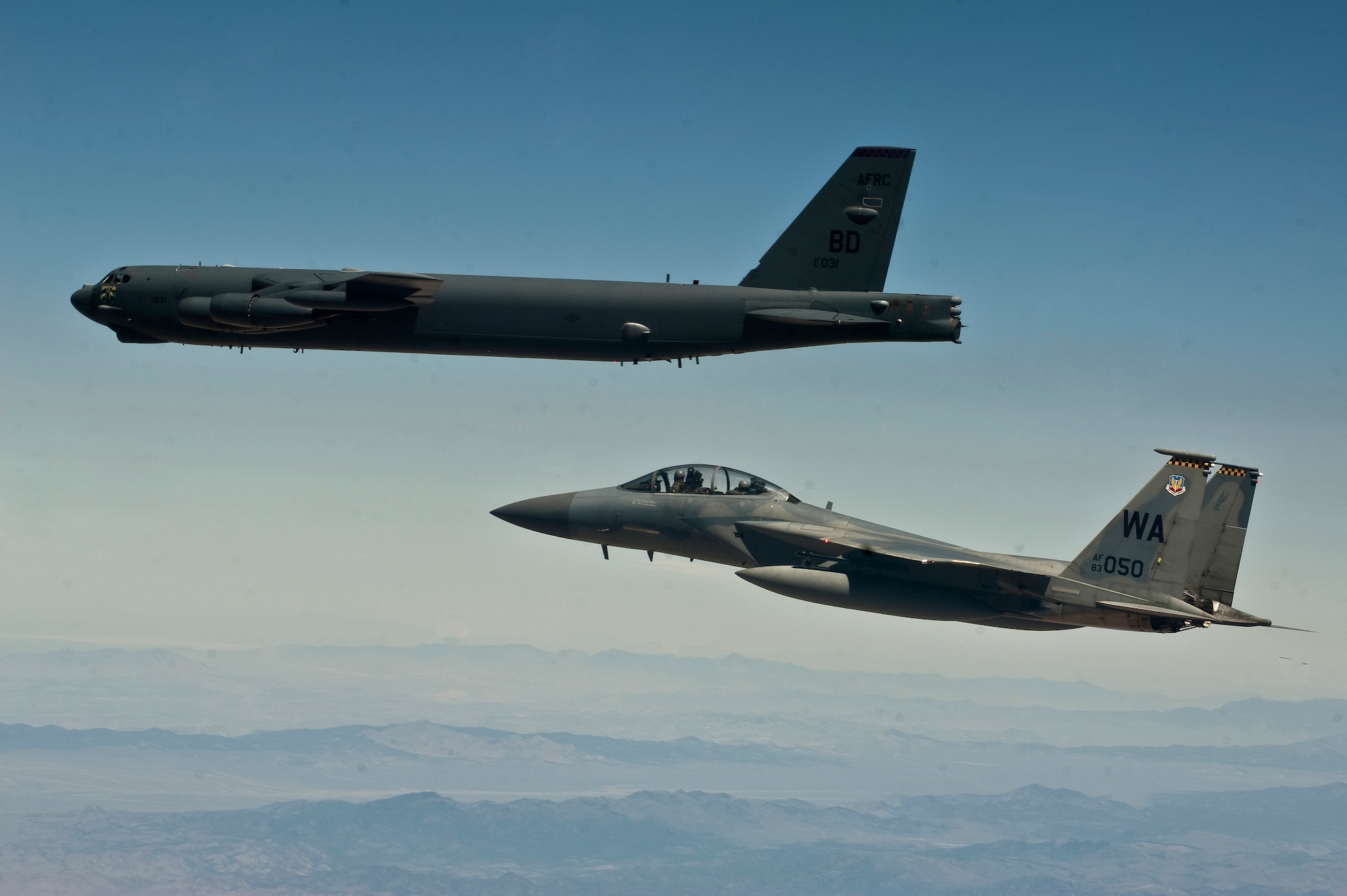A U.S. Air Force F-15D Eagle, 433rd Weapons School, flies next to a B-52 Stratofortress, Barksdale Air Force Base, La., during MIDWAY WHITE III June 28, 2012, over the Nevada Test and Training Range. MIDWAY WHITE III serves to further establish a new paradigm for quick response demonstrations to meet immediate non-forecasted warfighter needs. (U.S. Air Force photo by Staff Sgt. Christopher Hubenthal)