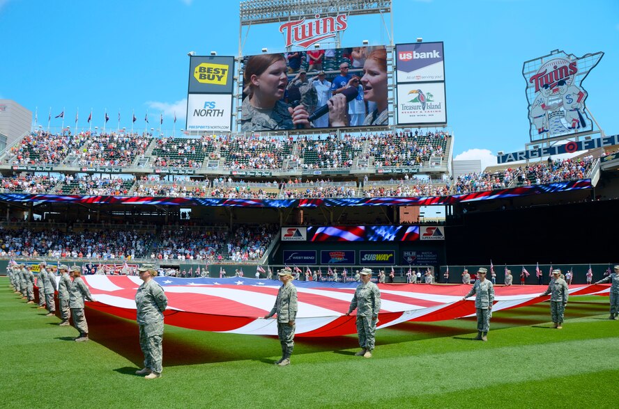 Women from all services were honored Sunday, July 1, 2012 at Target Field in Minneapolis as the Minnesota Twins held military appreciation day. A formation of about thirty women in uniform took up part of the outfield as a large flag held by members of the Minnesota National Guard filled up more. The singers for the Star Spangled Banner, pictured on the large screen, were 2nd Lt. Darcy Reller and Airman 1st Class Jessica Reller of the 133rd Airlift Wing. U.S. Air Force photo by Staff Sgt. Jonathan Young