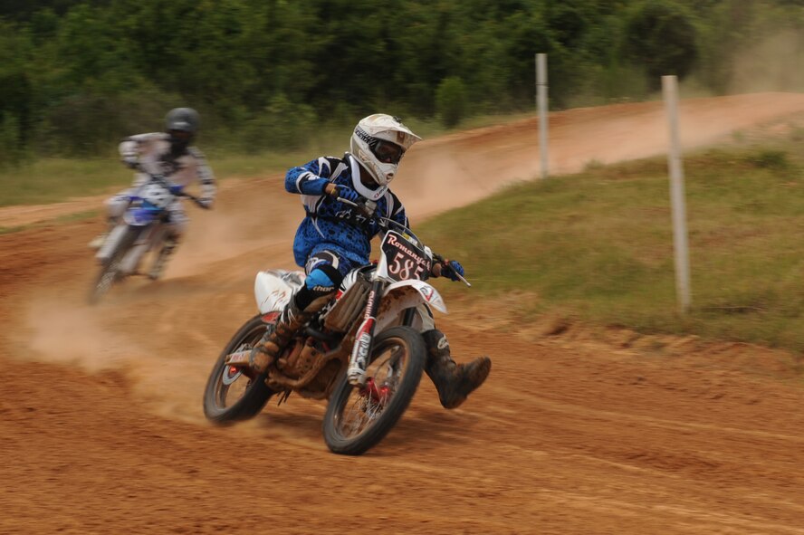 Airman 1st Class Michael Romanyak, 2nd Maintenance Squadron, speeds through a turn at a dirt track in Mansfield, La., July 1. Romanyak has been riding dirt bikes since he was 12 years old and enjoys competing in local Motocross competitions. (U.S. Air Force photo/Airman 1st Class Micaiah Anthony)(RELEASED)
