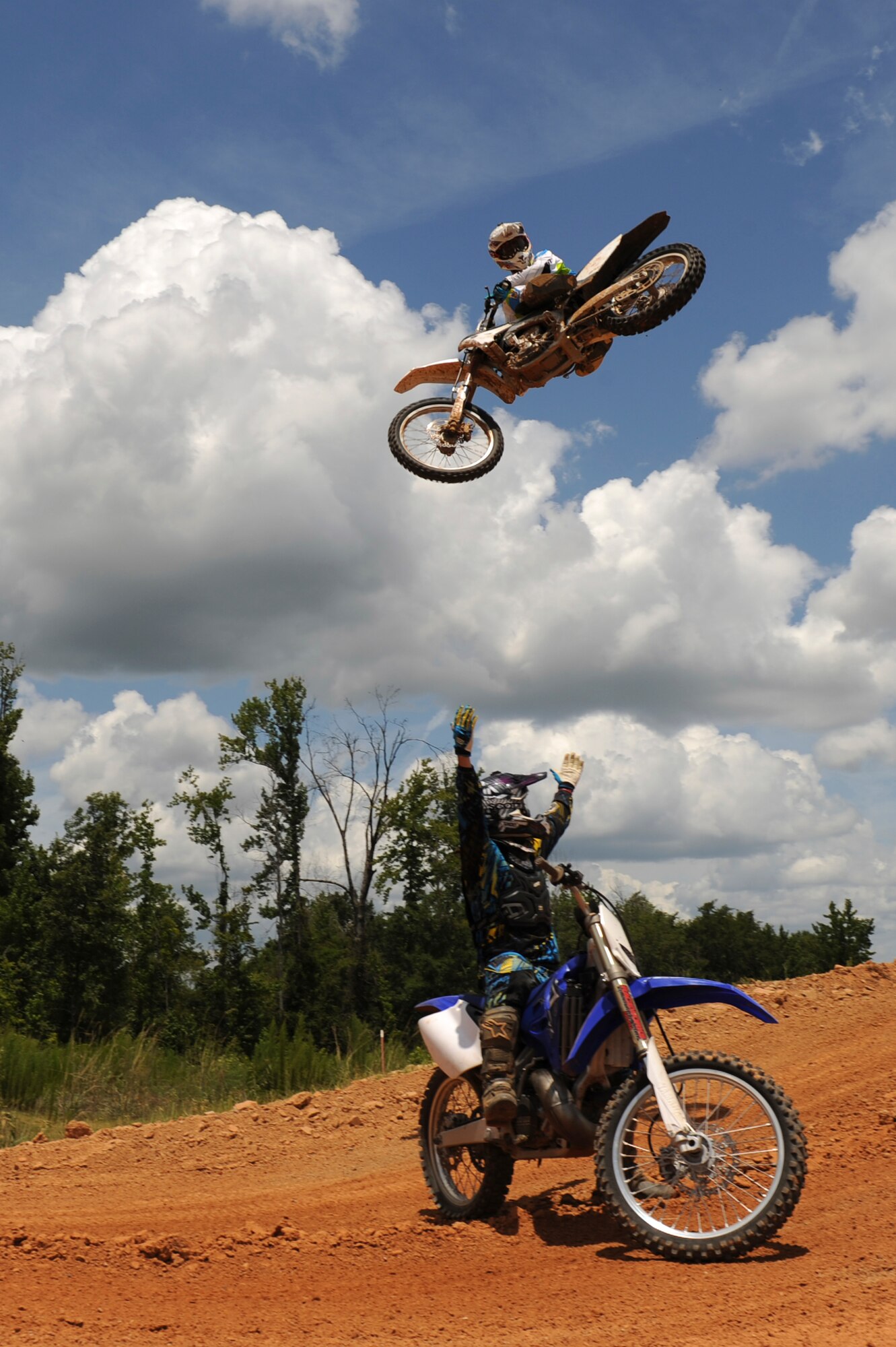A local dirt bike enthusiast jumps over a fellow rider at a dirt track in Mansfield, La., July 1. A few Barksdale Air Force Base Airmen enjoy riding and racing dirt bikes to unwind after a long work week. In order to ride and race dirt bikes, Airmen must complete the motorcycle safety course at Barksdale Air Force Base along with having a high-risk activity briefing from their commander. (U.S. Air Force photo/Airman 1st Class Micaiah Anthony)(RELEASED)
