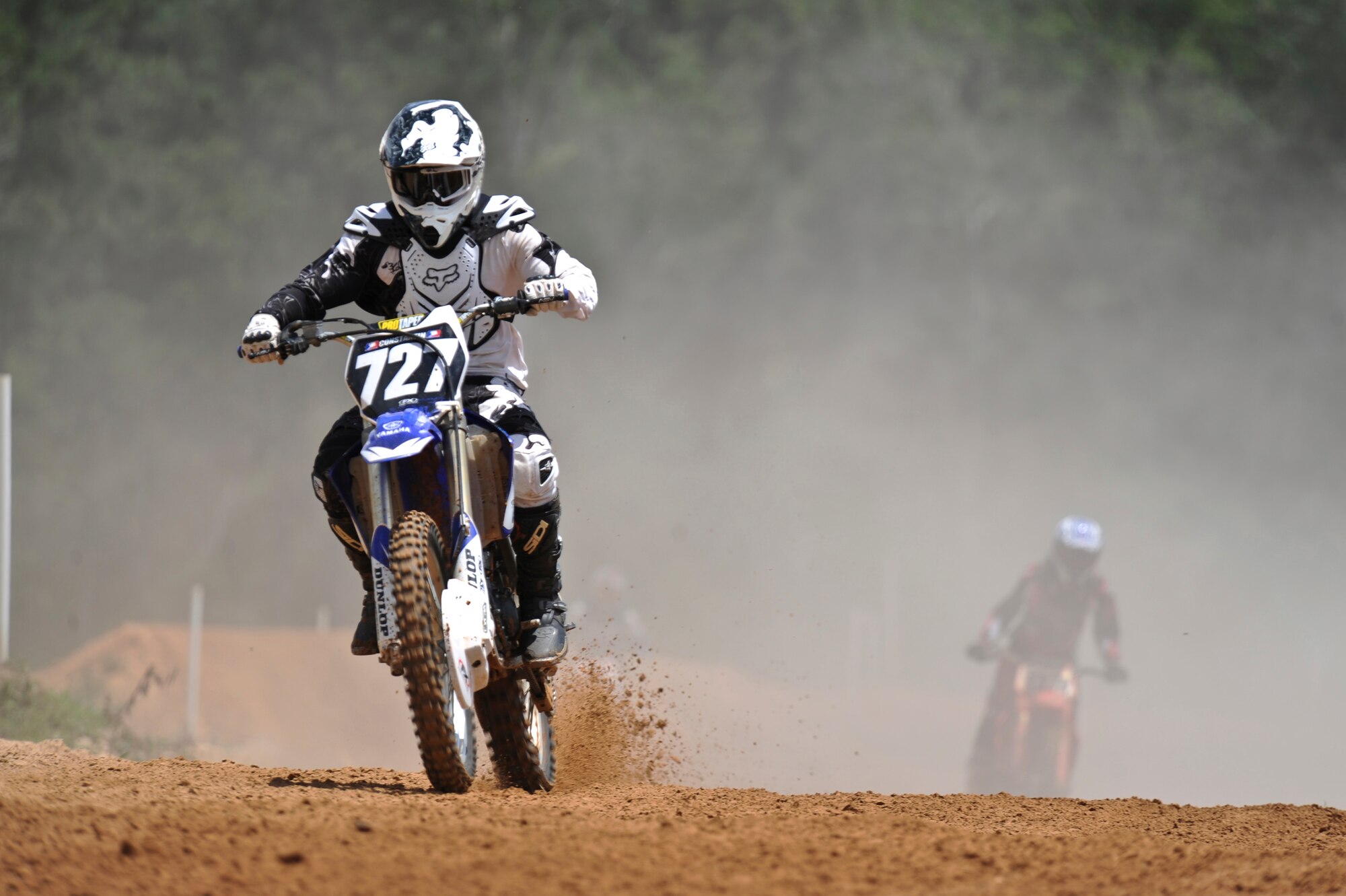 Tech. Sgt. Ryan Constantin, 2nd Logistics Readiness Squadron, accelerates after riding through a series of small hills at a dirt track in Mansfield, La., July 1. Three years ago Constantin returned to the sport after a 10 year break. He plans on participating in his first official Motocross race July 7-8. (U.S. Air Force photo/Airman 1st Class Micaiah Anthony)(RELEASED)
