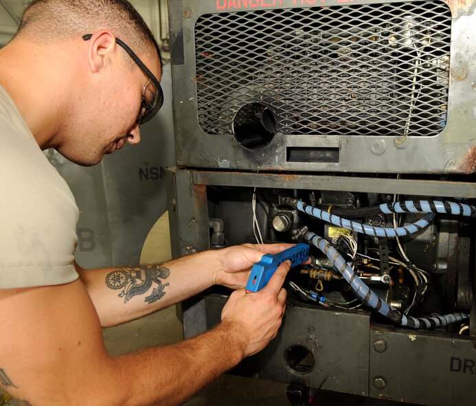 Senior Airman Joseph Remy, 2nd Maintenance Squadron aerospace ground equipment flight team leader, chafe wraps fuel lines on an MJ-1B bomb lift on Barksdale Air Force Base, La., July 3. Remy wrapped the lines during an inspection of the bomb lift to prevent them from damage during operation. The MJ-1B is used to hold and lift munitions weighing up to 3,000 pounds. (U.S. Air Force photo/Airman 1st Class Joseph A. Pag?n Jr.)(RELEASED)