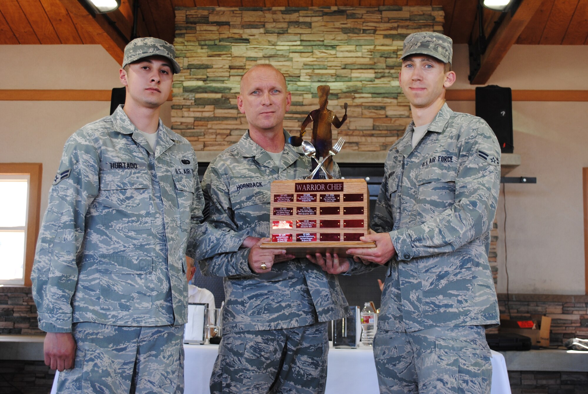 Chief Master Sgt. Brian Hornback, Air Force Global Strike Command command chief, presents the Warrior Chef trophy to the winners of the quarterly challenge, Airman 1st Class Edward Hurtado, left, and Airman 1st Class Kyle Murphy, both 10th Missile Squadron missile chefs. Hornback was the presiding judge in the challenge. The two competitors will have their name engraved on the coveted Warrior Chef trophy as 2012’s 2nd-Quarter Warrior Chef Competition winners. (U.S. Air Force photo/Airman 1st Class Katrina Heikkinen)