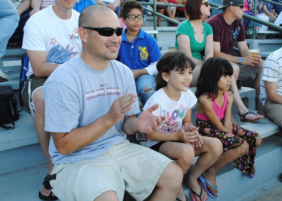Senior Master Sgt. Kraig Nadjkovic, 819th RED HORSE Squadron first sergeant, is all smiles during Military Appreciation Night at the Great Falls Voyagers baseball game with his daughters Aidan, 8, and Kendall, 6. Military members received free admission and a coupon for a free small fountain drink at the game. (U.S. Air Force photo/Airman 1st Class Katrina Heikkinen)