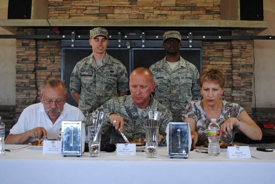 Chief Master Sgt. Brian Hornback, Air Force Global Strike Command command chief, center, along with Jim Thul, retired Malmstrom barber, left, and Ingrid Callahan, 341st Force Support Squadron chief of the force development flight, judge Senior Airmen Robert Reichensperger, left background, and Jamel Prevost, both 490th Missile Squadron missile chefs, dish during the 2nd-Quarter Warrior Chef Competition. Hornback, the presiding judge in the competition, visited Malmstrom June 27 to 30 and toured the Elkhorn Dining Facility, the Detour, the First Term Airman's Center, Airman Leadership School and Explosive Ordnance Disposal. (U.S. Air Force photo/Airman 1st Class Katrina Heikkinen)