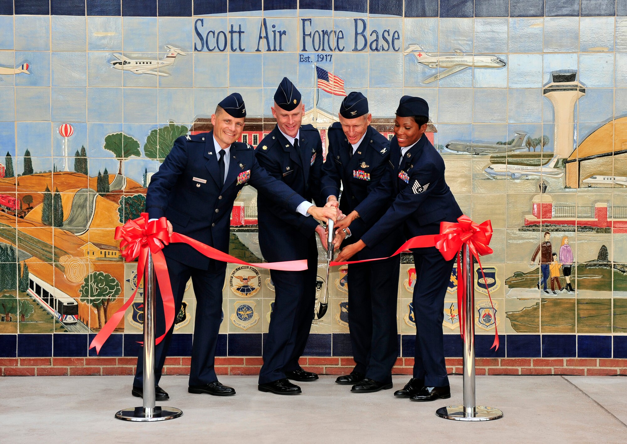 Retired Col. Michael Hornitschek, Maj. Russell Callaway, Col. David Almand, 375th Air Mobility Wing commander and Tech. Sgt. Shena Hayes cut the ribbon to the new Consolidated Education, testing and training center and Student union signifying the grand opening on Scott Air Force Base, Ill June 2, 2012. The Student Union, the first in Air Mobility Command, came as a way to support and reinforce the ideas found in the Comprehensive Airman Fitness philosophy, and provide a new place for Team Scott members and students to use for recreational activities and studying. Also inside the educational center will was reconstructed to provide three more classrooms and a Cafe that will open in mid-August. (U.S. Air Force photo/ Staff Sgt. Stephenie Wade)