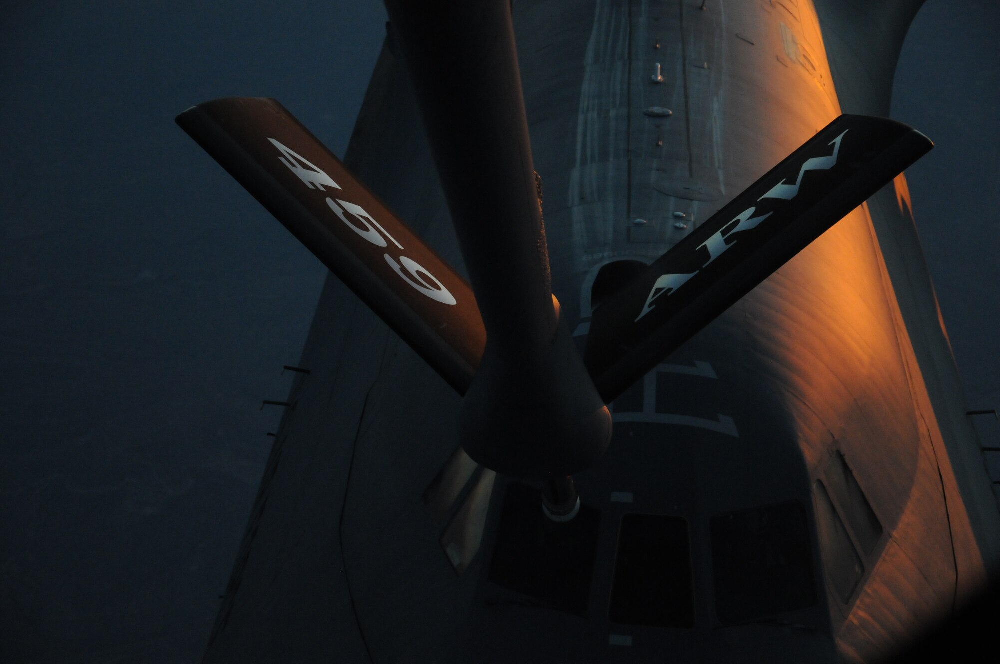 The setting sun reflects off the side of a Lockheed C-5 Galaxy aircraft of the 356th Airlift Squadron as the boom from a KC-135 Stratotanker of the 459th Air Refueling Wing gets into position to make contact for air-to-air refueling, June 28. The KC-135 crew is assisting the 356th AS for a business effort where new C-5 pilots get qualified on aerial refueling. (U.S. Air Force photo/Senior Airman Katie Spencer)