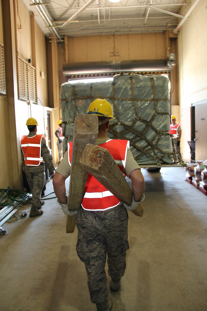 ROBINS AIR FORCE BASE, Ga. -- Senior Airman William Wilson, right, guides forklift driver Senior Airman Benjamin Moore as he loads a pallet of communications equipment on a flatbed truck here June 28 while Senior Airman Jarvis Griffin, left, brings dunnage used for shipping the pallet to the truck. All three are assigned to the 51st CBCS is postured and on-call with nearly 123,000 pounds of communications equipment to support wildfire operations in Colorado. (U.S. Air Force photo by Robert Talenti)