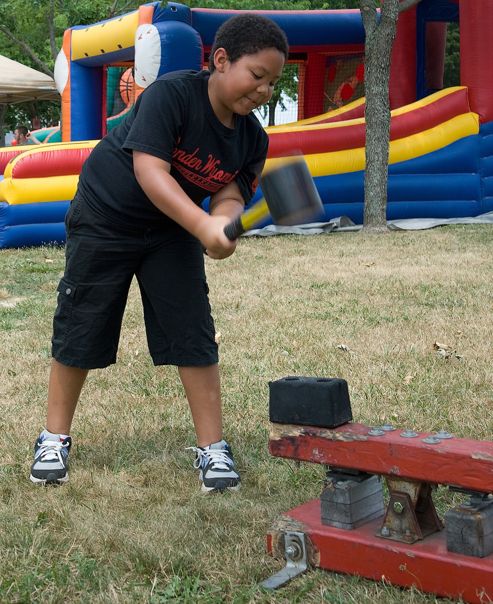 Richie Sironen tests his strength in the strongman game at the Wing Picnic July 3, 2012, at Dover Air Force Base, Del. The strongman game was one of many games children could enjoy at the base-wide event. (U.S. Air Force photo by Adrian Rowan)